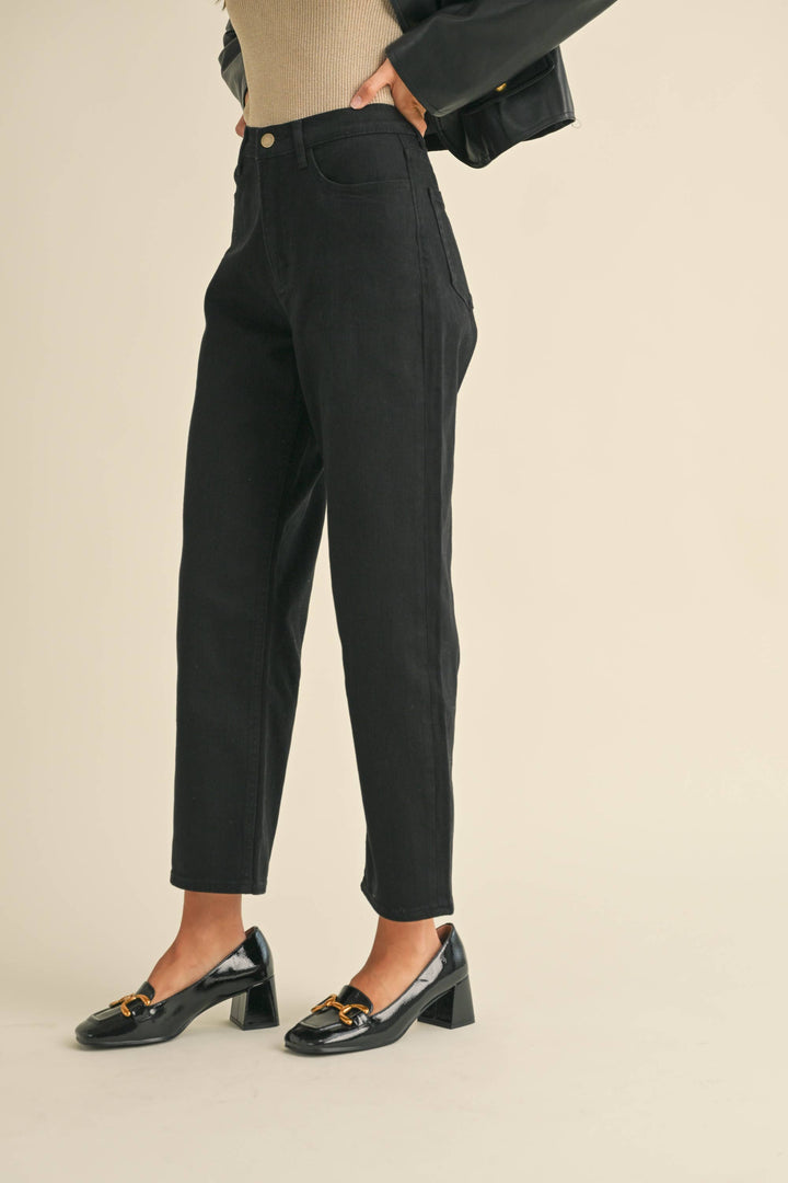 Person wearing tapered cotton pants in black.