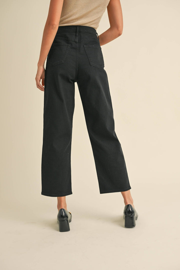 Person wearing tapered cotton pants in black.